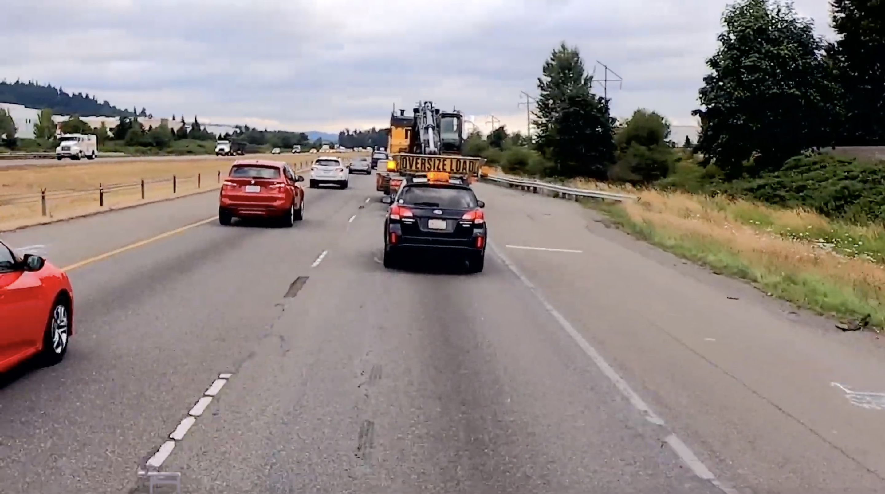 Pilot car escorting oversized load on highway